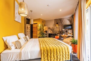 A modern bedroom with a bed, a TV, and a desk area.
