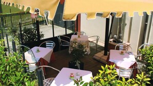 An outdoor patio area with tables and chairs under a large canopy. - Albergo Ristorante Fratte (Fregona)