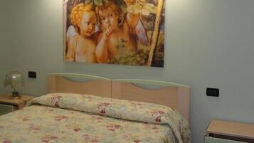 Un dormitorio con cama, mesita de noche y lámpara de pared.