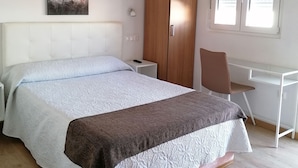 A bedroom with a bed, a desk, and a wardrobe. - Hostal Adelia (A Coruña)