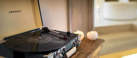 A turntable on a wooden surface with a candle in the background.