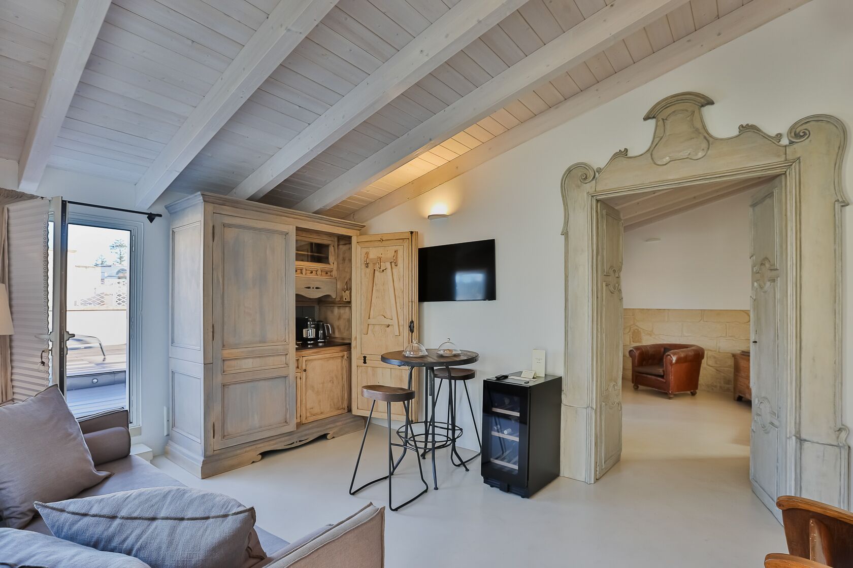 A cozy living room with a sofa, a wooden cabinet, a TV, and a fireplace.
