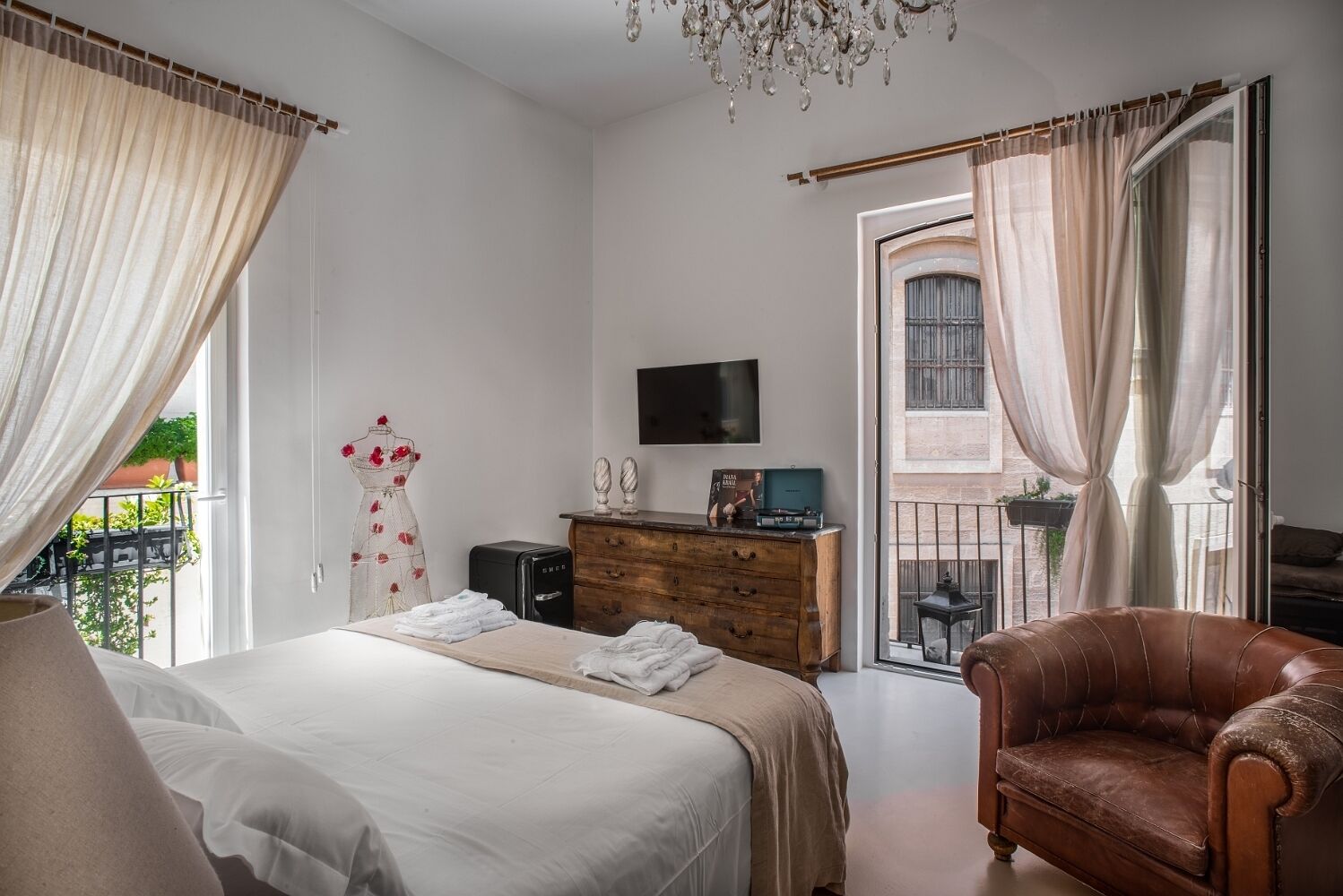A bedroom with a bed, a dresser, a TV, and a chair.