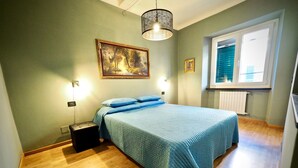 A bedroom with a bed, a painting, a window, and a radiator. - Lussuosa Dimora San Lorenzo (Genoa)