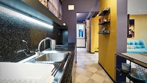A modern kitchen with a stainless steel sink and a black granite countertop. - Lussuosa Dimora San Lorenzo (Genoa)