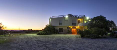 Vista frontal de la propiedad por la tarde o noche