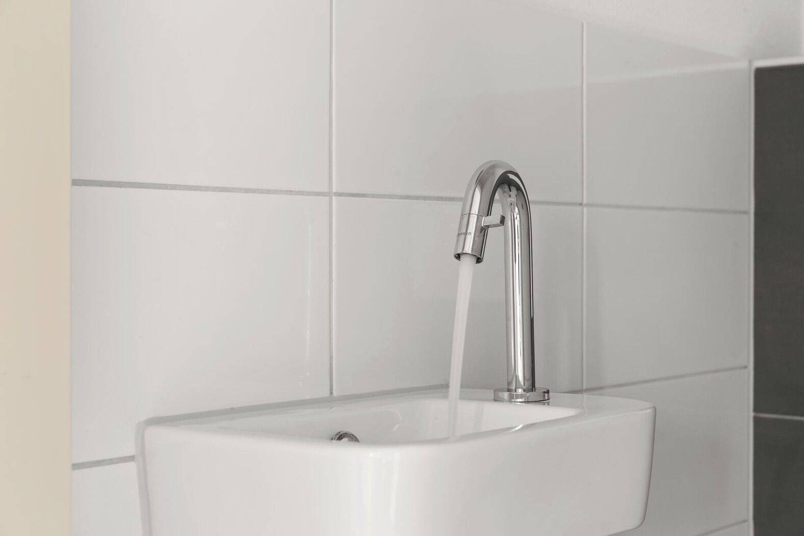 Une salle de bain moderne avec un robinet chromé et un lavabo blanc.