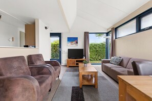 Una sala de estar moderna con un sof á, una mesa de centro y un televisor.