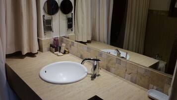 A bathroom with a white sink, a mirror, and a towel rack.
