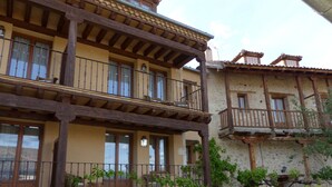 A traditional building with a balcony, stone walls, and wooden beams. - Hostería del Arco (Pedraza)