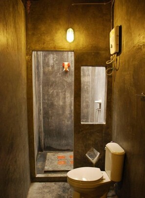 Un baño pequeño con inodoro, ducha y espejo.