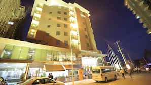 Un hotel moderno a più piani, con balconi su ogni piano e un ristorante a livello strada.