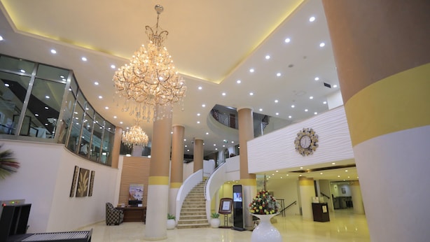 Un'ampia hall con un imponente lampadario, una scalinata e una reception.