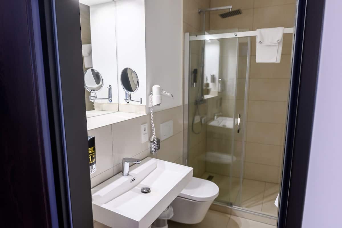 standard twin room | bathroom | shower, hair dryer, slippers, towels