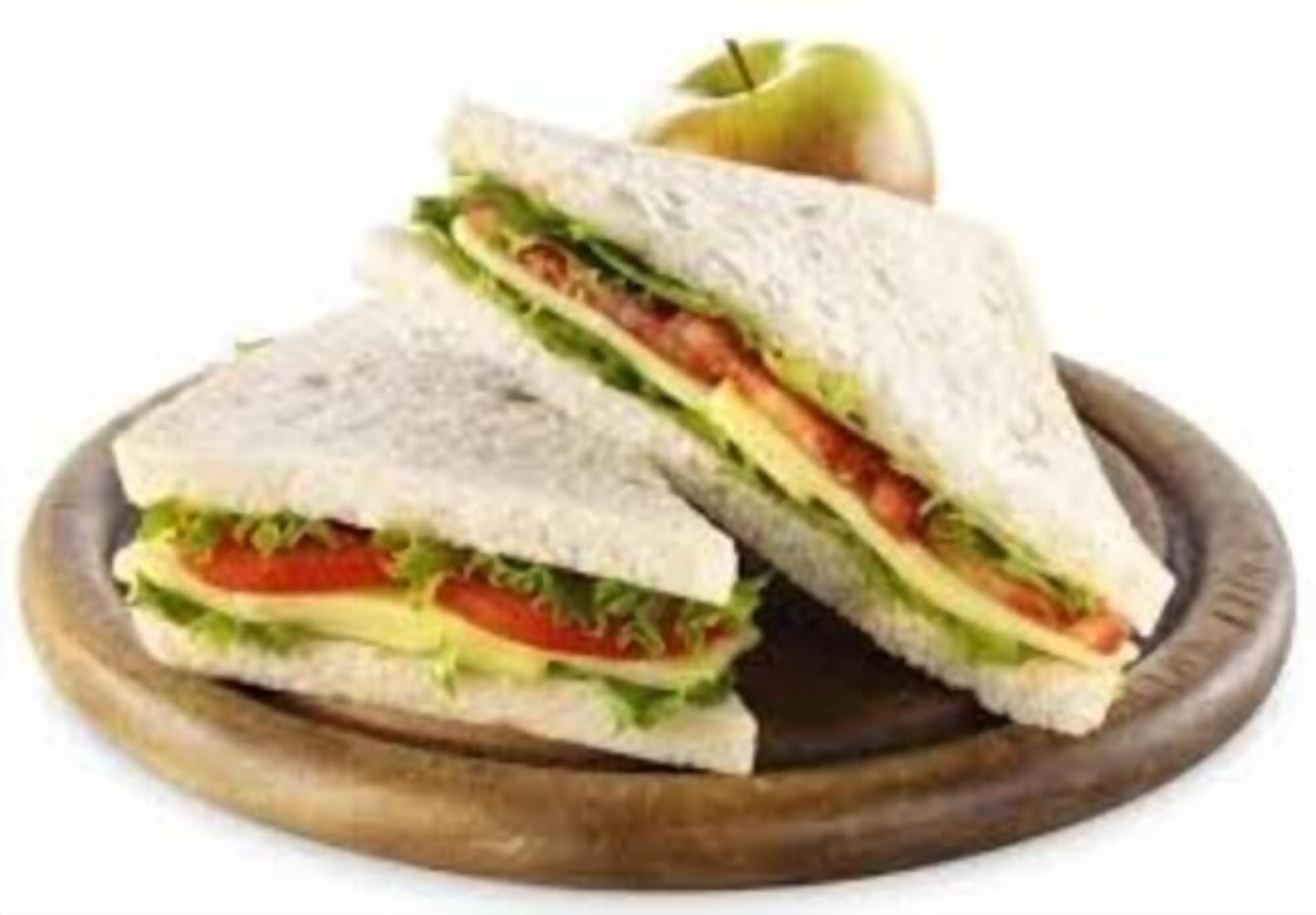 A sandwich cut in half, placed on a wooden board.