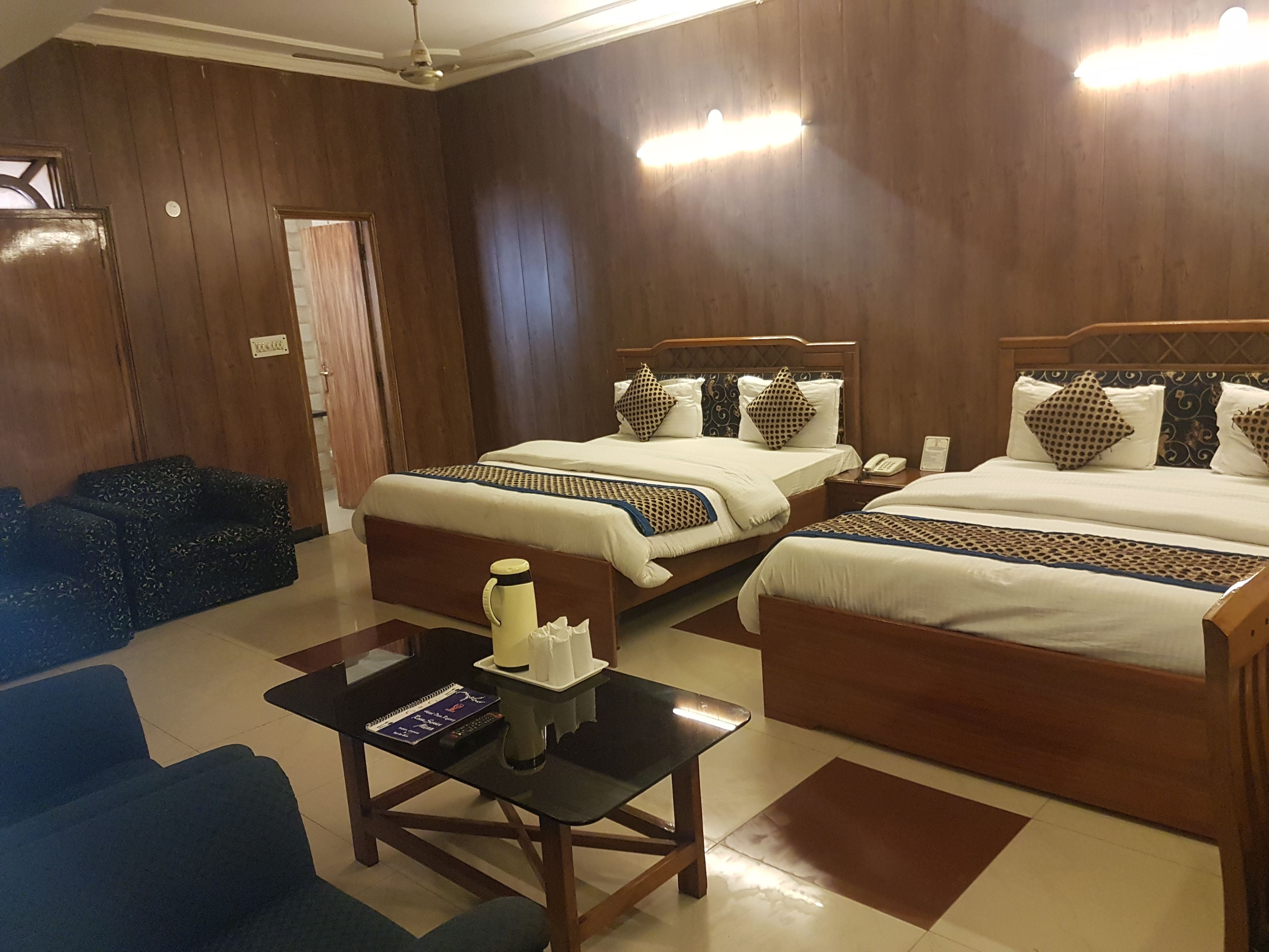 Habitación de hotel con dos camas, un escritorio y un sofá.