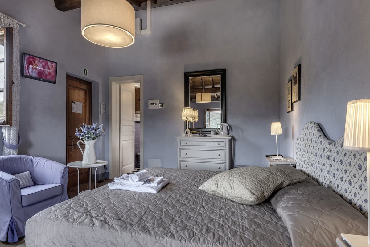 Une chambre à coucher avec un grand lit, une commode, une chaise et une petite table.