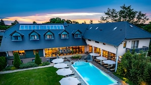 A modern house with a swimming pool, outdoor seating, and a well-maintained garden.