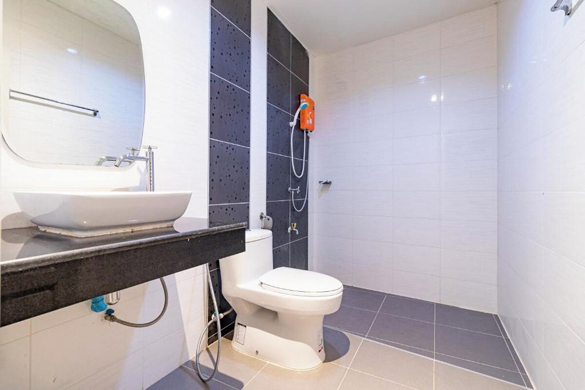 Une salle de bain avec un lavabo blanc, des toilettes et un espace douche.