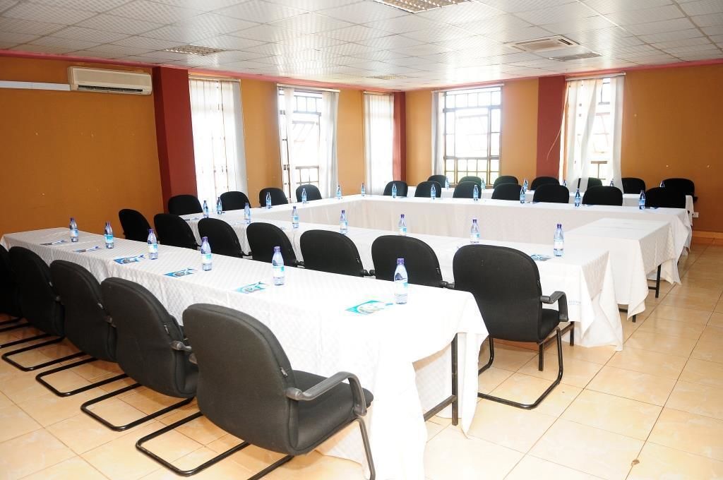 A conference room with long tables, chairs, and water bottles.