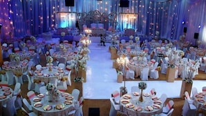 A banquet hall with round tables, white chairs, and floral centerpieces. - Silver Springs Hotel Uganda (Kampala)