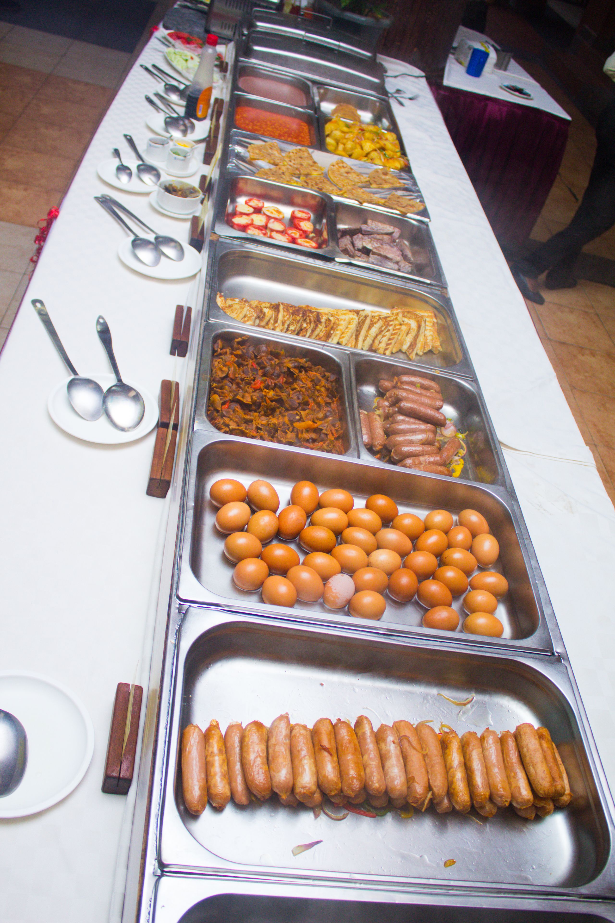 Een buffet met verschillende soorten eten en bestek.