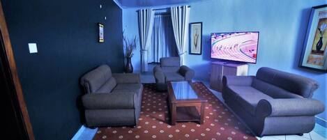 A living room with two sofas, a coffee table, and a TV on a stand.
