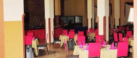 A restaurant with a sign reading 'Voyager Restaurant' and multiple tables with red chairs.