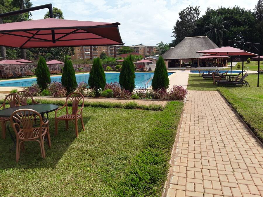 Un espace aménagé au bord de la piscine, avec des chaises longues, une table et des parasols.