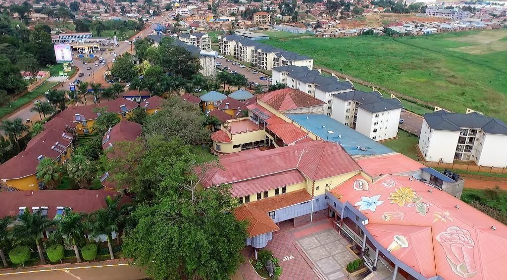 An aerial view of a residential area with multiple buildings, including a large complex with a central courtyard and several smaller structures.
