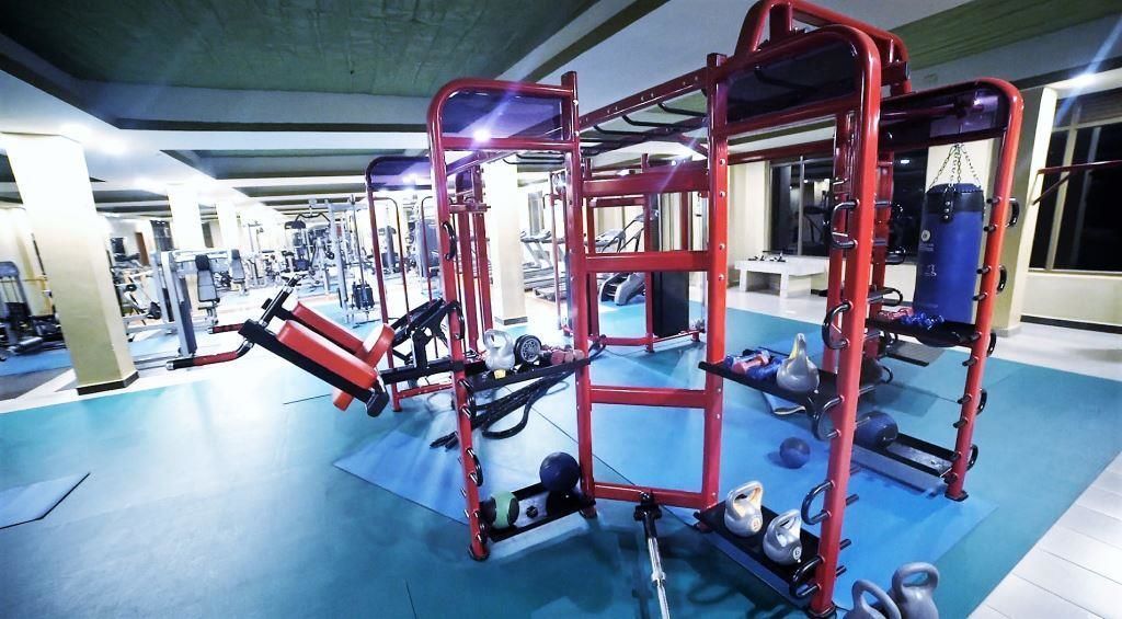 A gym with various exercise equipment, including weight machines and free weights.