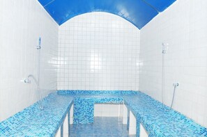 A swimming pool with blue mosaic tiles and a clear blue sky visible through the ceiling. - Silver Springs Hotel Uganda (Kampala)