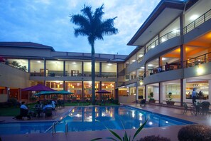 A hotel with a pool, outdoor seating, and multiple balconies. - Silver Springs Hotel Uganda (Kampala)