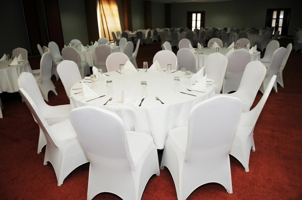 A conference room with round tables and white chairs, arranged for a meeting or event.