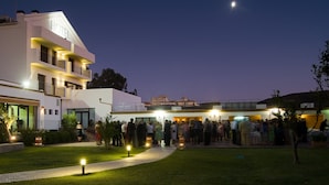 Un hotel con diseño moderno, que cuenta con varios balcones y un área exterior bien iluminada.
