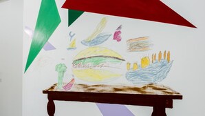 A table with a colorful drawing of food items and geometric shapes on the wall behind it. - B&B il Castelluccio (Arezzo)
