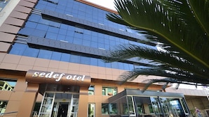 Un hotel moderno con fachada de vidrio y un letrero que dice "sedef hotel".