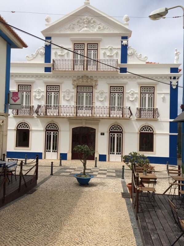 A building with a white facade, blue trim, and ornate balconies.