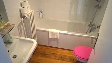 Un baño con bañera, inodoro y lavamanos.
