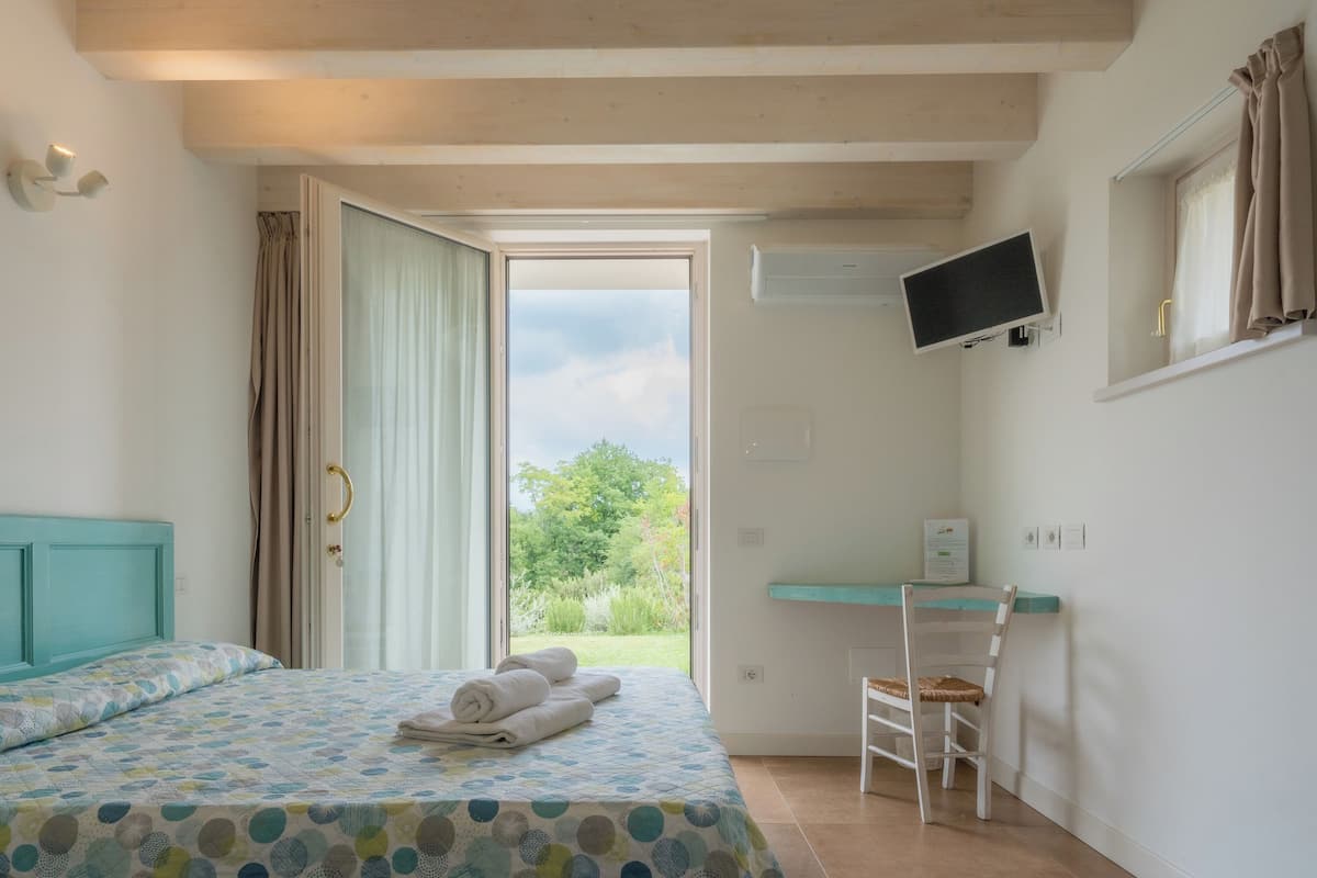 Ein Schlafzimmer mit Bett, Schreibtisch, Stuhl und Fernseher.