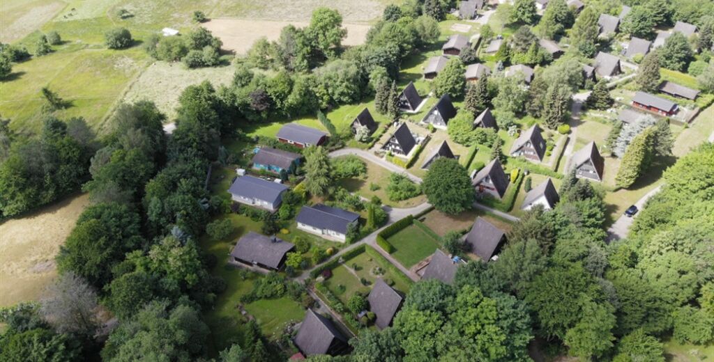 An aerial view of a residential area with houses surrounded by greenery.