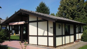 A traditional building with a tiled roof, numbered 133, featuring a combination of white and dark wooden panels. - Holiday park- Robinson (Waldbrunn)