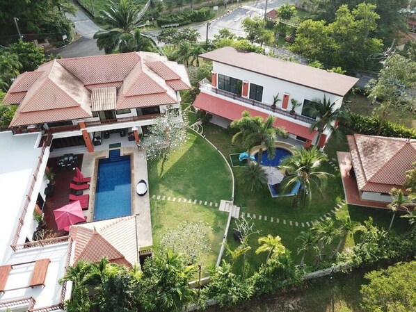 Una propiedad residencial con piscina, cancha de tenis y un jardín bien cuidado.
