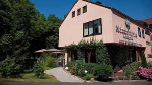 A two-story building with a sign that reads "Niestracht Hotel." There is a paved pathway leading to the entrance, and the building is surrounded by greenery. - Restaurant Niedmühle Land & Genuss Hotel (Rehlingen-Siersburg)