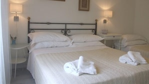 Et hotelværelse med en seng, to sengeborde og to vægmonterede lamper.