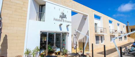 A hotel with outdoor seating and a sign reading "Palazzo di Francia."
