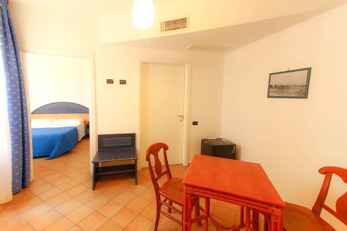 Una habitación con cama, escritorio, silla y mesa.