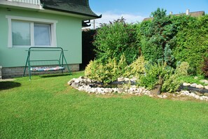Enjoy the serene atmosphere of this beautifully landscaped property with a swing set and tranquil water feature.