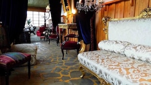 A room with a patterned carpet, a large ornate bed, a wooden headboard, and a chandelier. - A Hotel Boutique Pelluhue (Pelluhue)