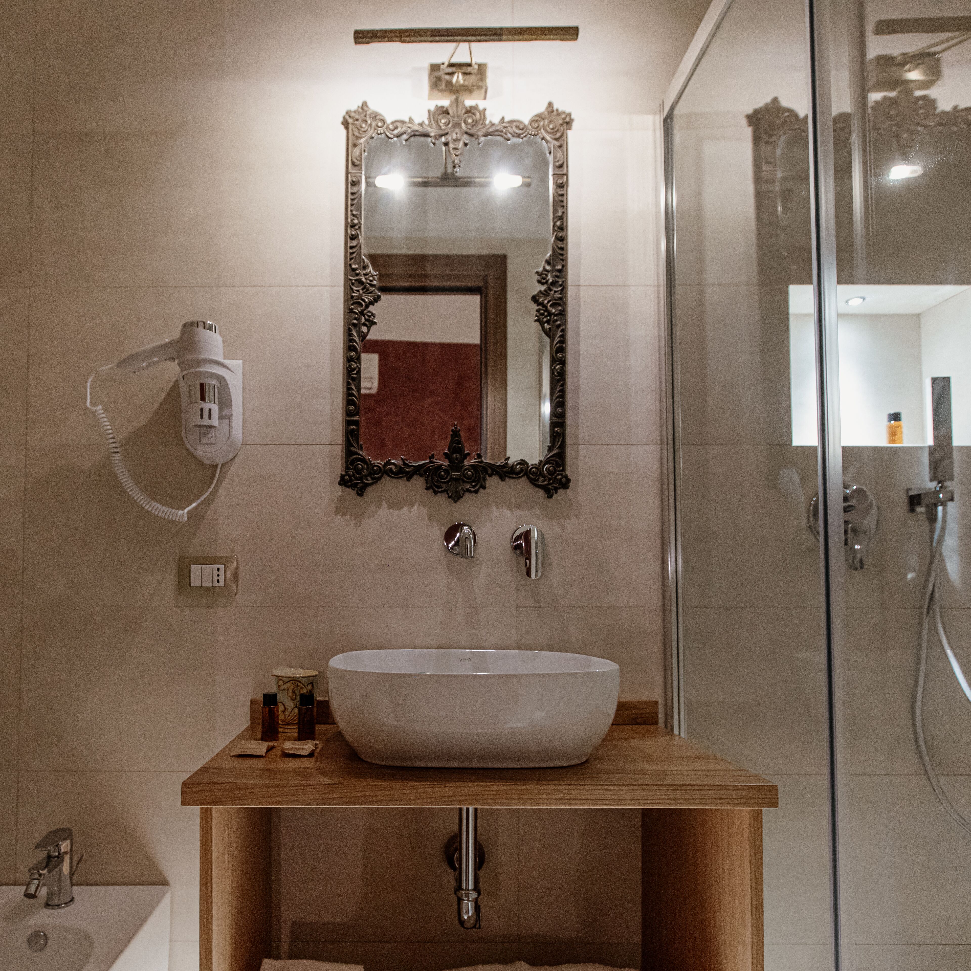 A bathroom with a large mirror, a sink, and a shower.